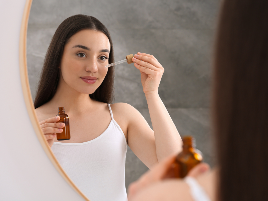 summer evening skincare routine wind down at home cleanser moisturiser face oil on bathroom shelf warm lighting