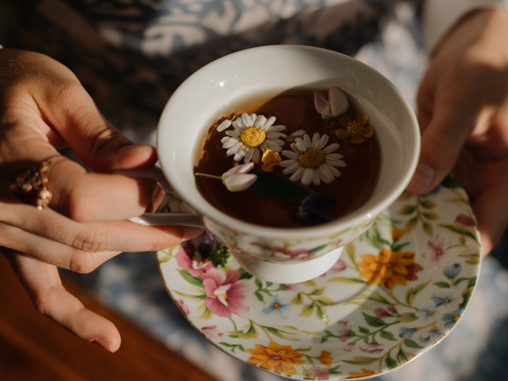 Chamomile tea in beautiful floral patterned tea cup and sourcer 