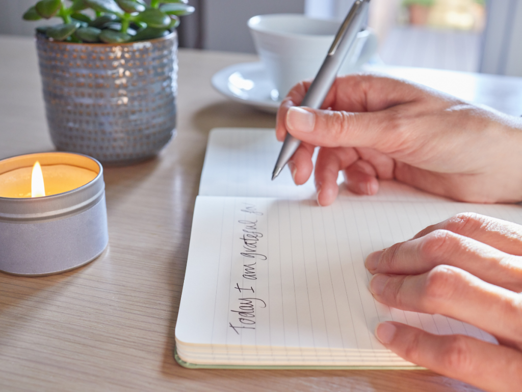 Woman writing in notebook sitting by sunny window summer morning routine