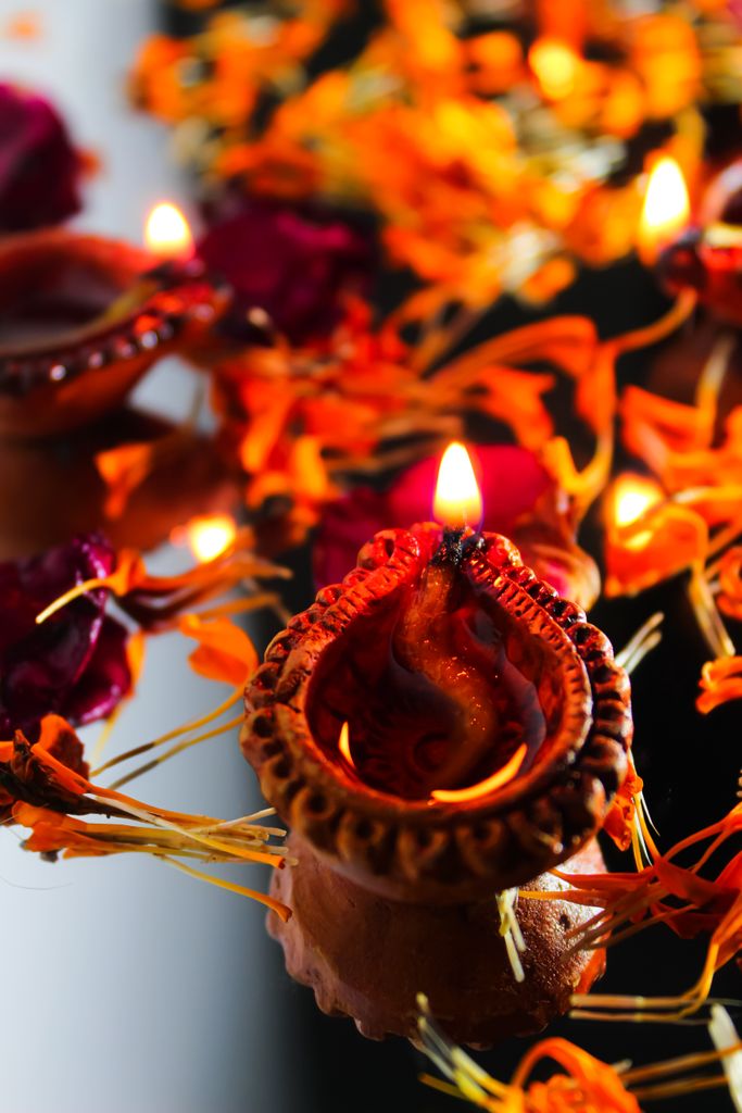 Traditional Diwali diya with vibrant marigold flowers and candlelight creating a festive atmosphere.