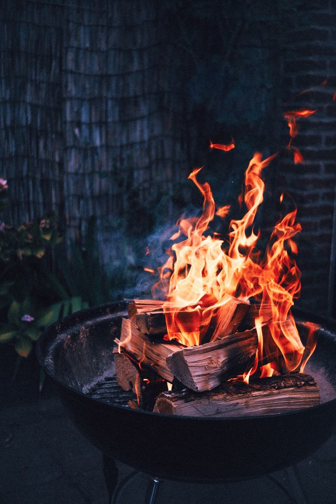 A cozy outdoor fire pit with bright flames, perfect for chilly evenings. Captures warmth and tranquillity on a summers evening