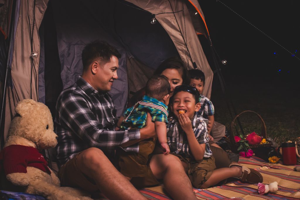Family of 5 Enjoying there backyard glamping with snacks