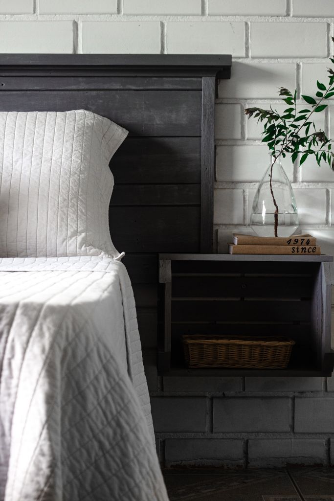 grey wooden headboard with built in storage either side of the bed