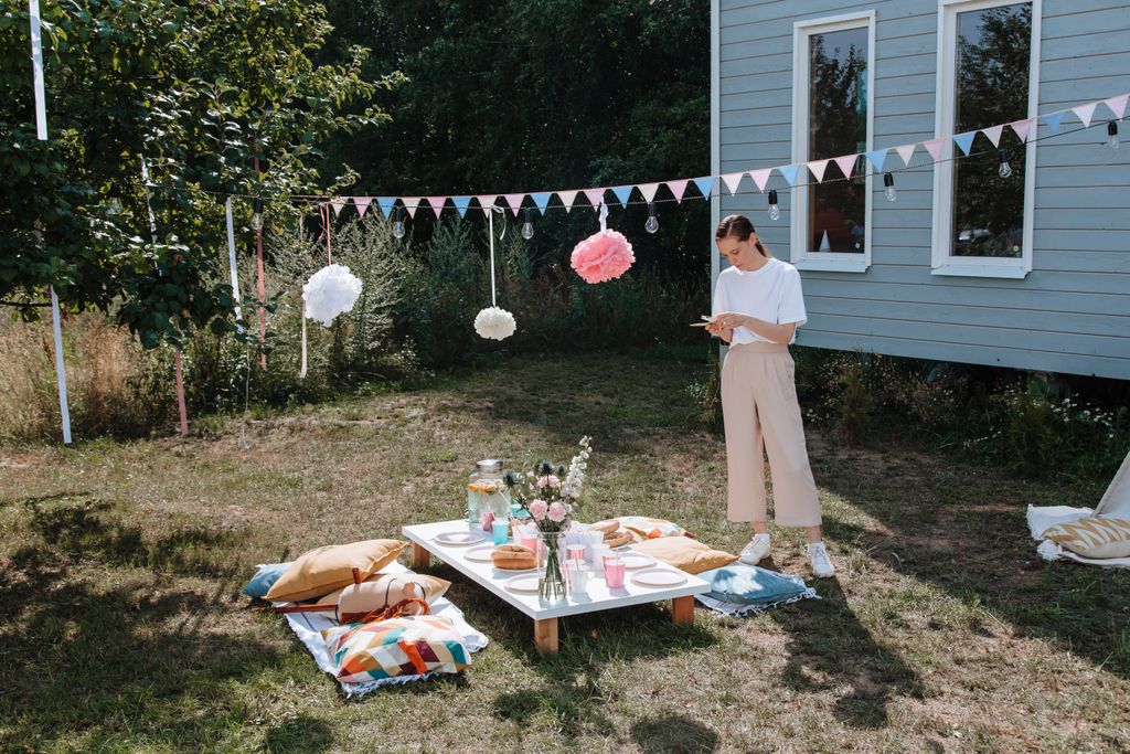 Woman Setting up cheerful decorations for a garden party shes hosting.