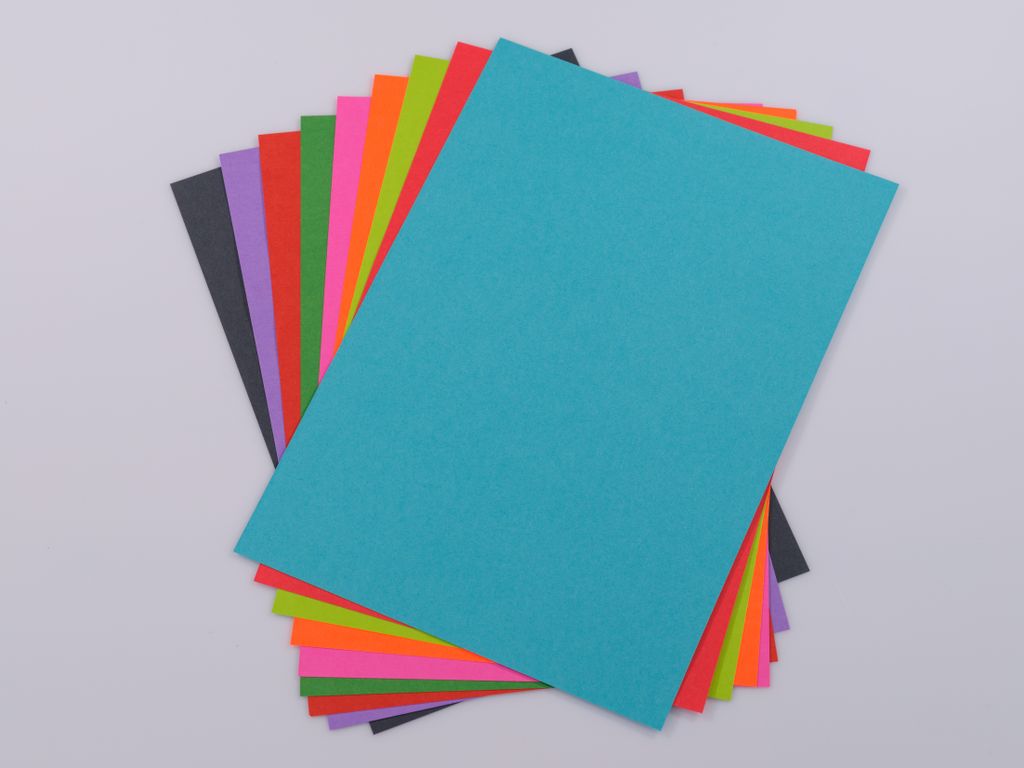 Moving essential High-quality vibrant colored paper stack on a neutral white background, perfect for creative projects.