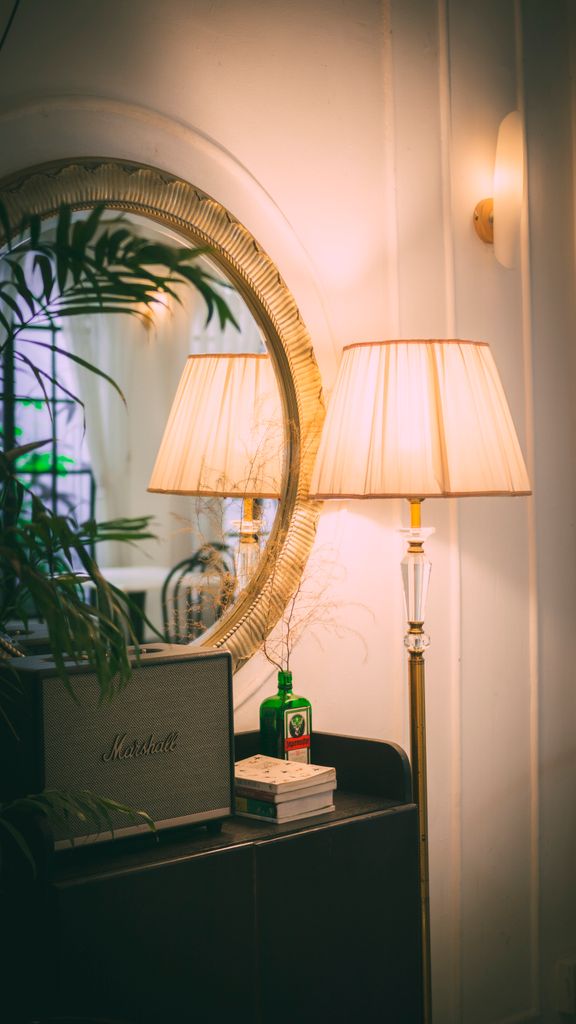 Luxurious room interior featuring a decorative lamp and mirror adding warmth and elegance.