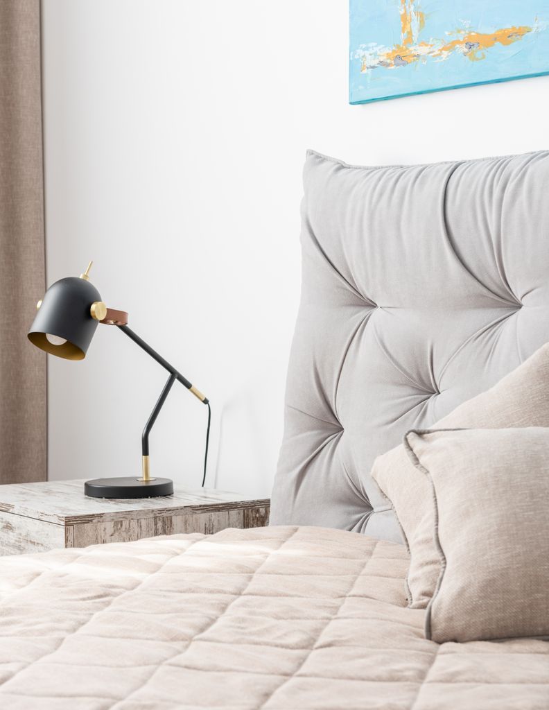 Modern white bedroom with loft style lamp and picture on wall in daytime