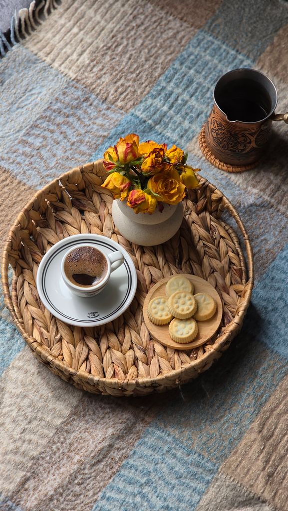 Warm autumn scene with coffee and cookies on a woven tray, perfect for cozy mornings.