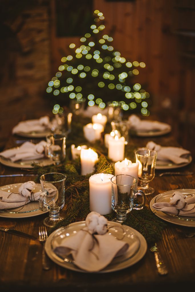 A beautifully arranged Christmas Eve dining table with candles and festive decorations.