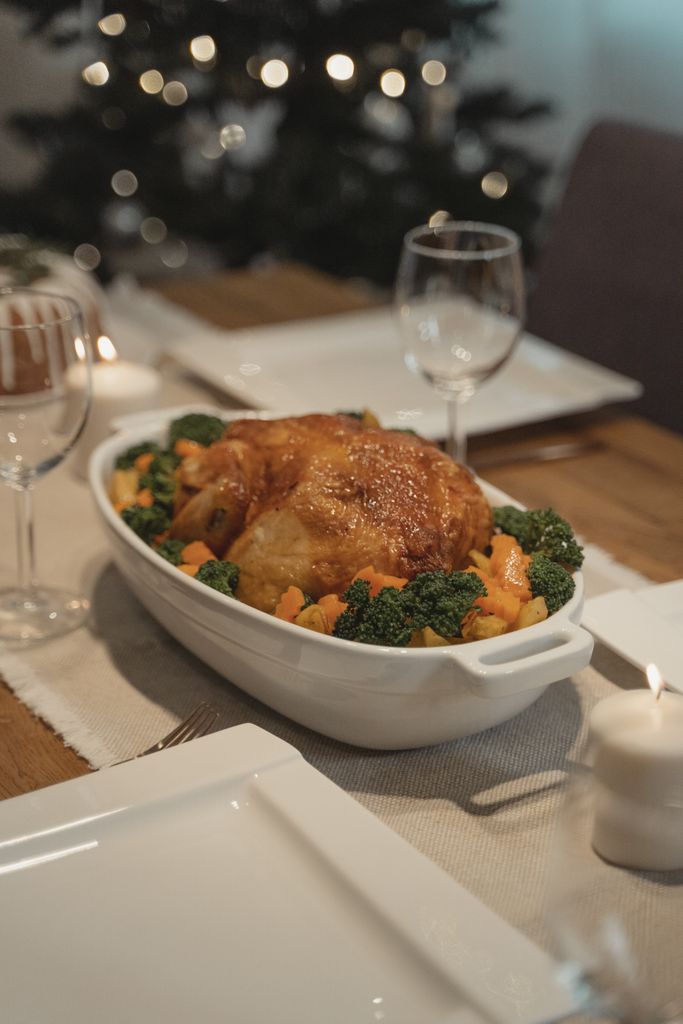 A cozy holiday dining table with a roasted turkey centerpiece and festive decor.
