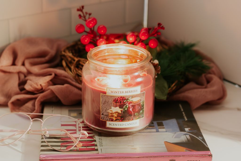 Cozy winter scene with a lit Winter Berries candle and festive decor.