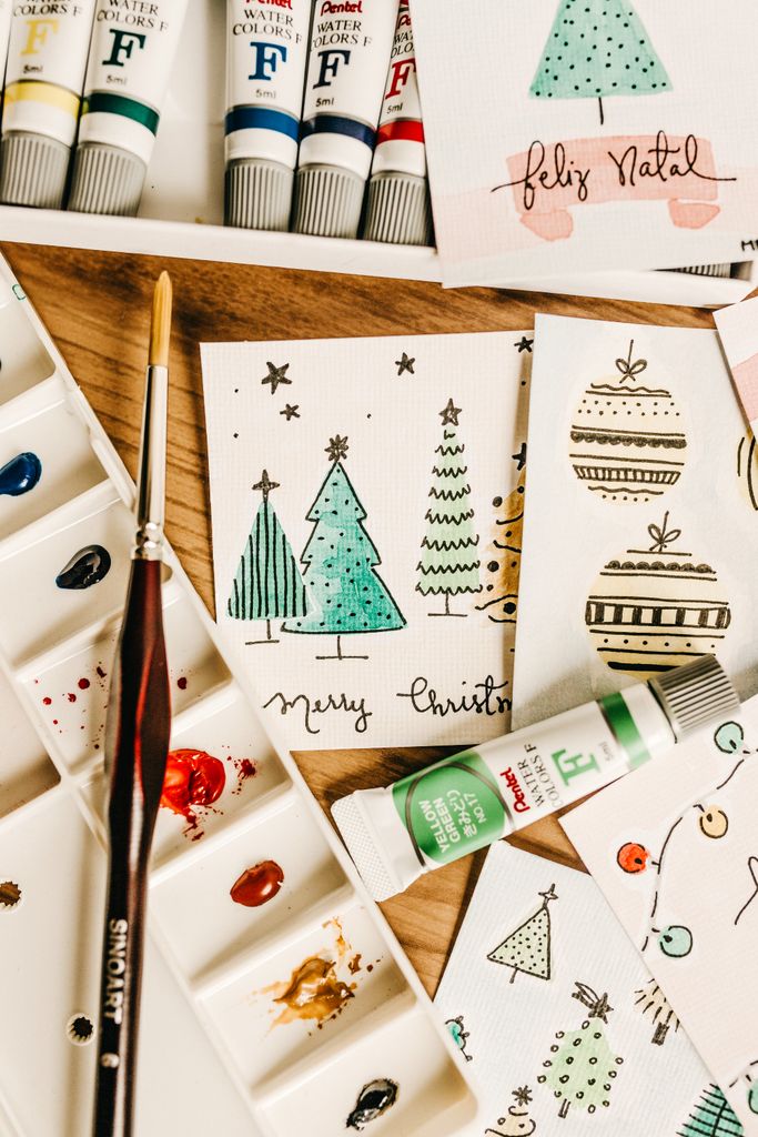 Creative handcrafted Christmas cards with watercolor art using tubes and brush.