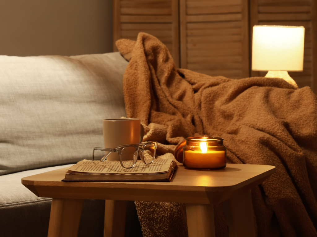 warm lighting from candle and lamp in cozy reading setting