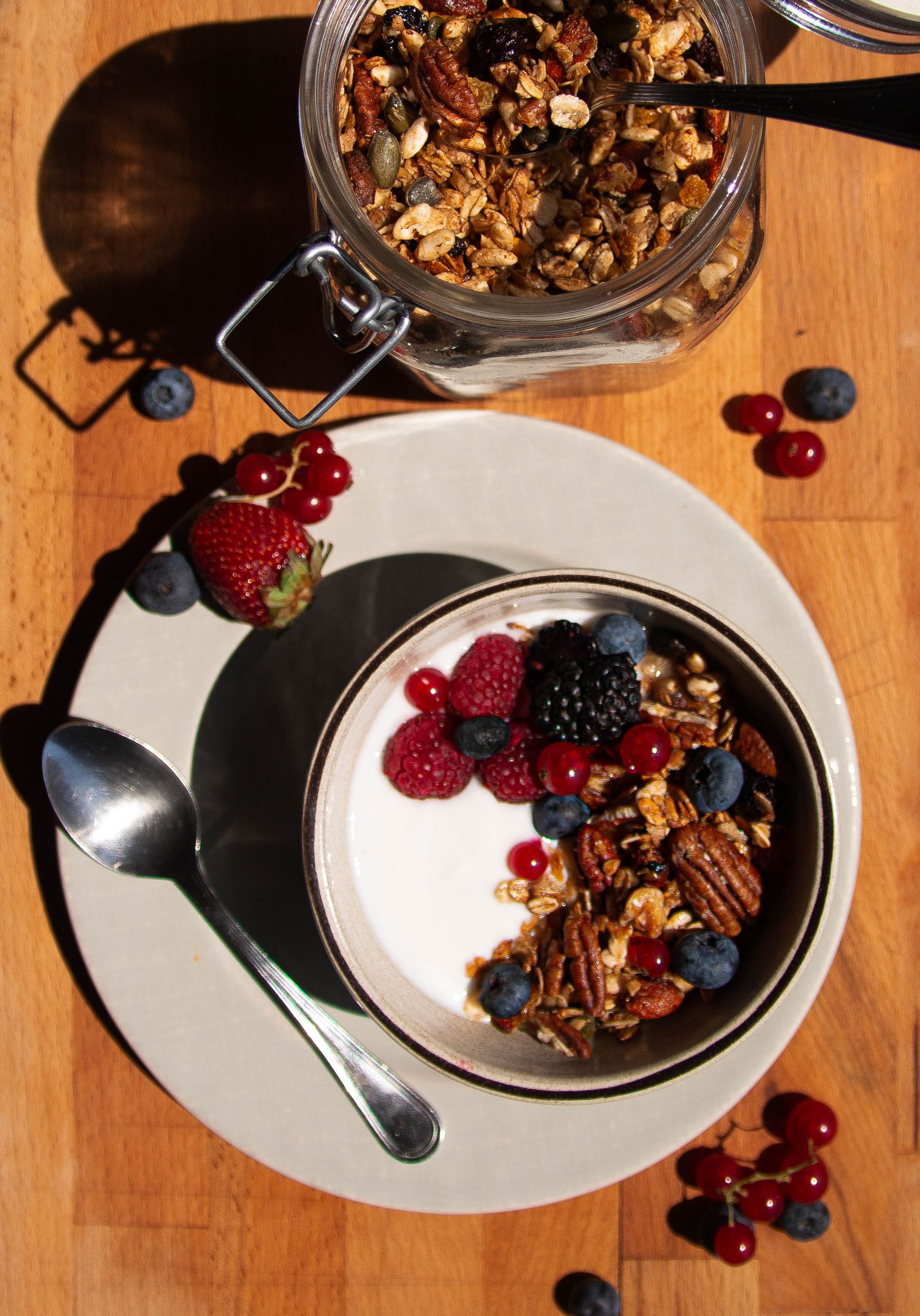 Top view of a healthy breakfast bowl with granola, assorted berries, and yogurt.