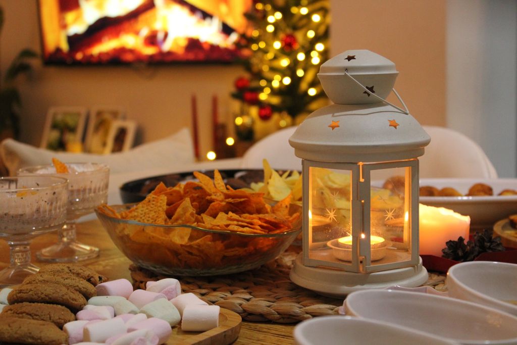 Warm and inviting holiday table setting with snacks and lantern in a cozy home atmosphere for a cozy Christmas Movie night