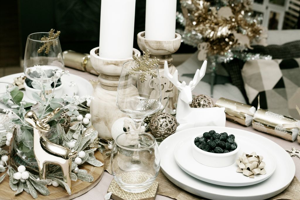 Beautifully decorated Christmas dinner table with candles, ornaments, and festive decor.