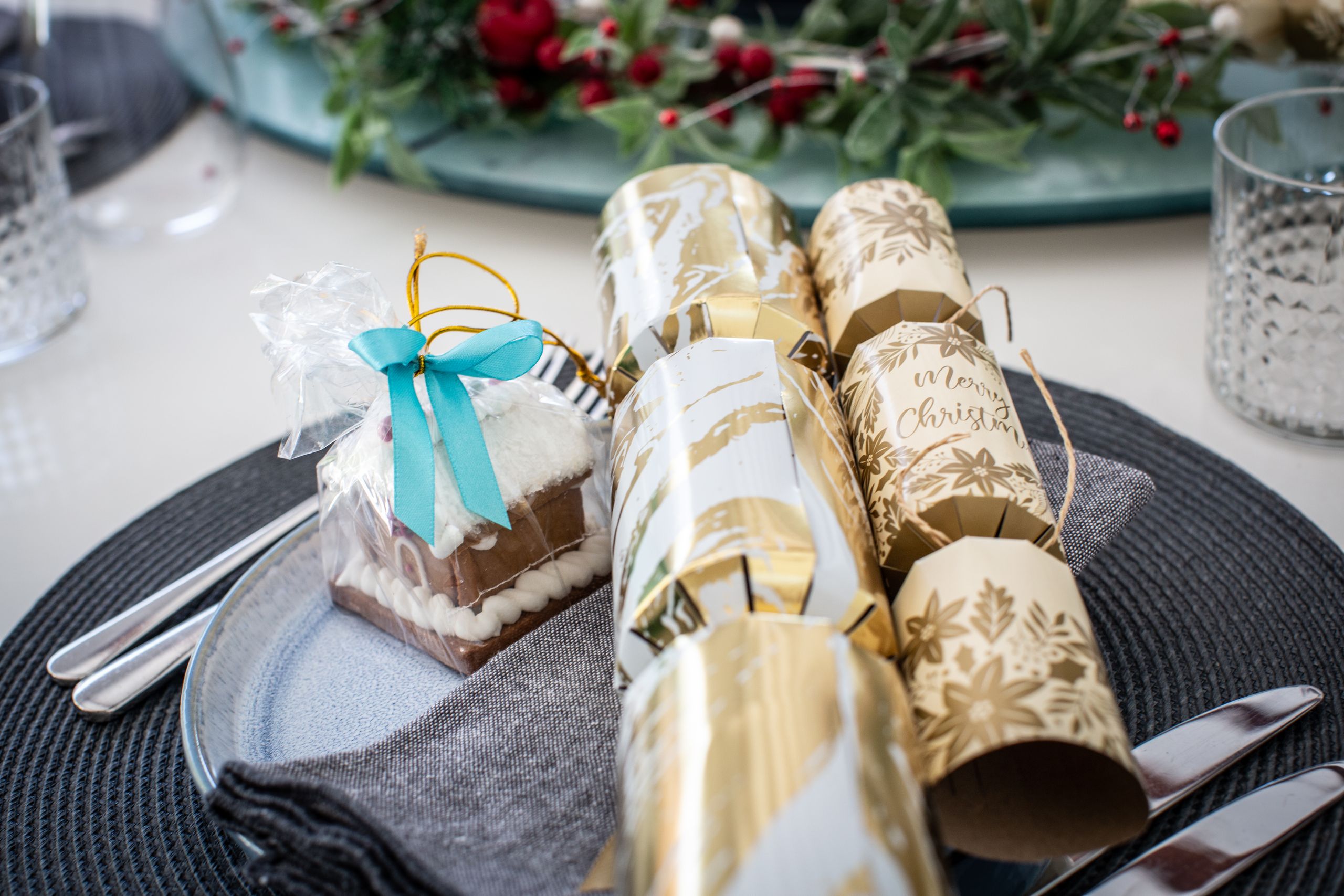 Stylish Christmas table setup with festive crackers and holiday decorations.