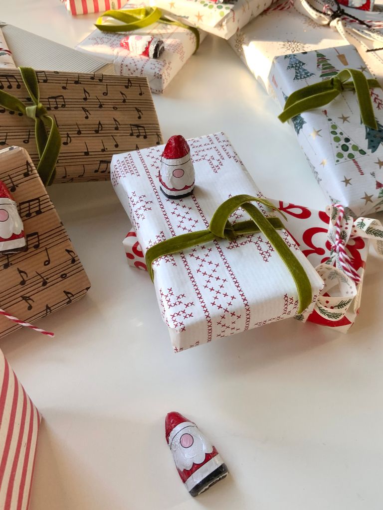 Beautifully wrapped Christmas gifts with decorative paper and playful gnome figures.