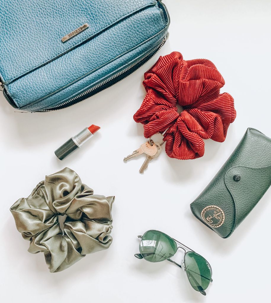 Overhead view of fashion items including scrunchies, purse, sunglasses, and more for advent calendar gift ideas for teen girls